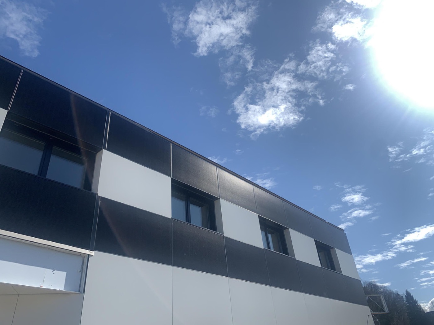 Photovoltaikmodule an einer Gebäudefassade im Gegenlicht der Sonne