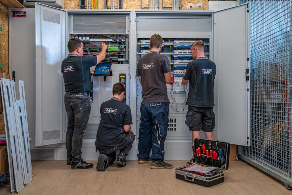 Elektrotechniker von Elektro Lang arbeiten an einem Verteilerschrank